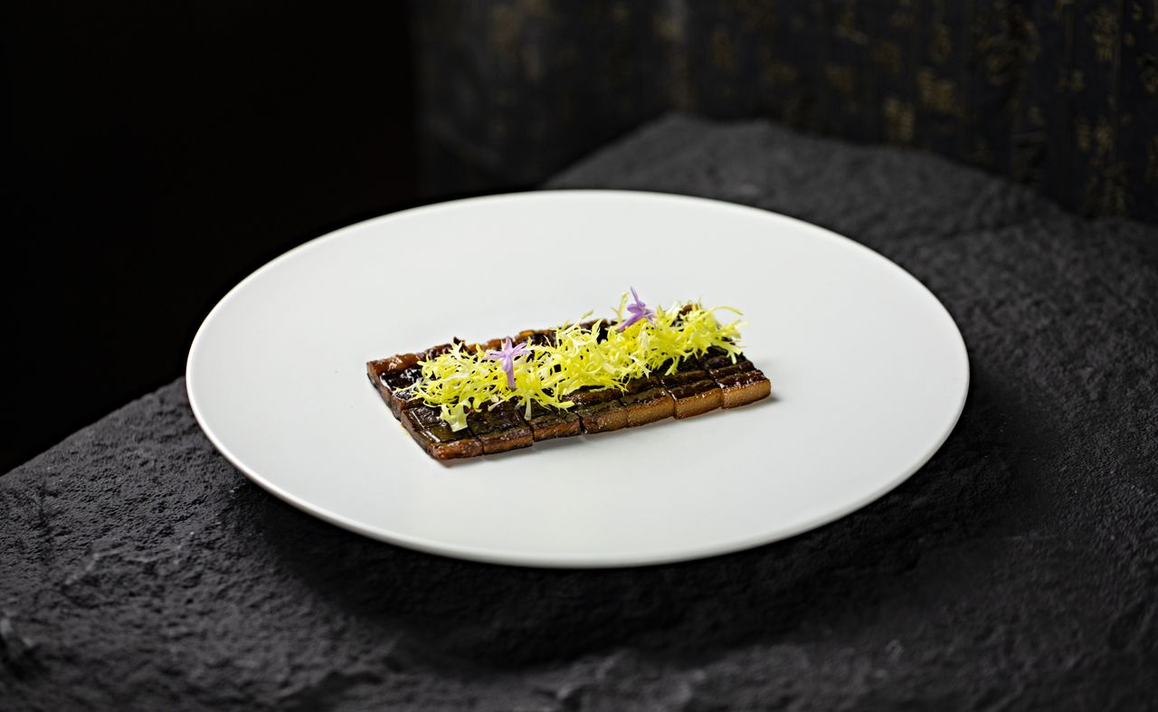 our-journey-03 Elegant gourmet dish garnished with edible flowers on a white plate. Perfect for fine dining concepts.